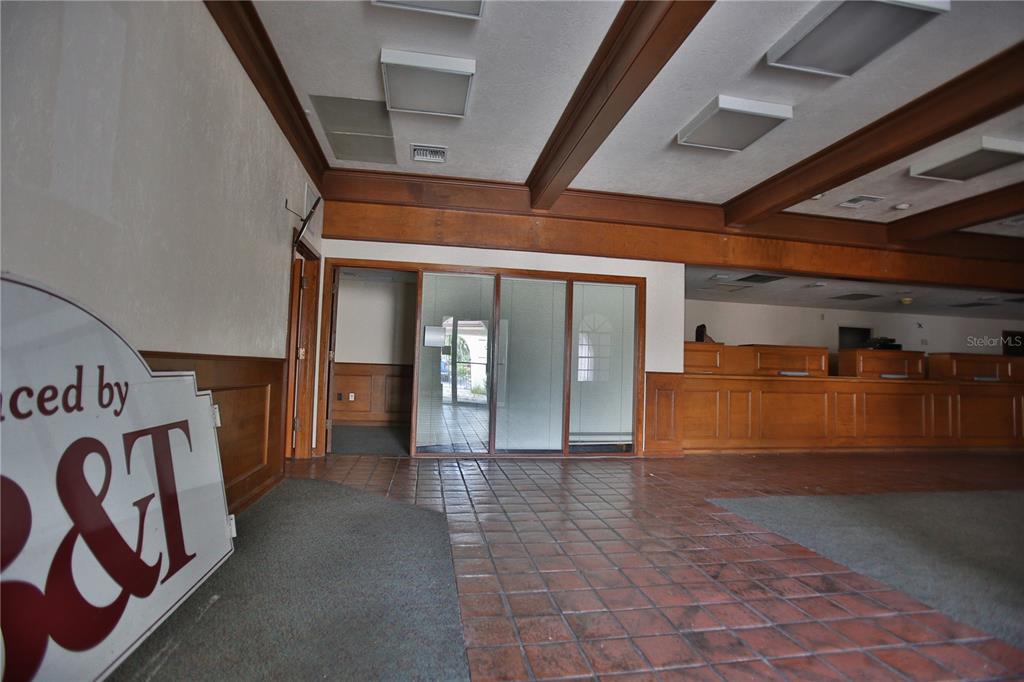 A large room features a mix of carpeted and tiled flooring, wood-paneled walls, and recessed lighting — 5431 E SILVER SPRINGS BOULEVARD UNIT A, SILVER SPRINGS, FL