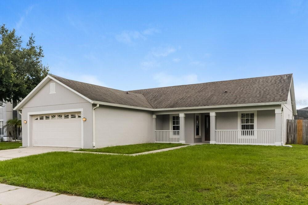 A single-story house with a gray exterior, a two-car garage, and a covered front porch — 5537 WILLOW BEND TRAIL, KISSIMMEE, FL