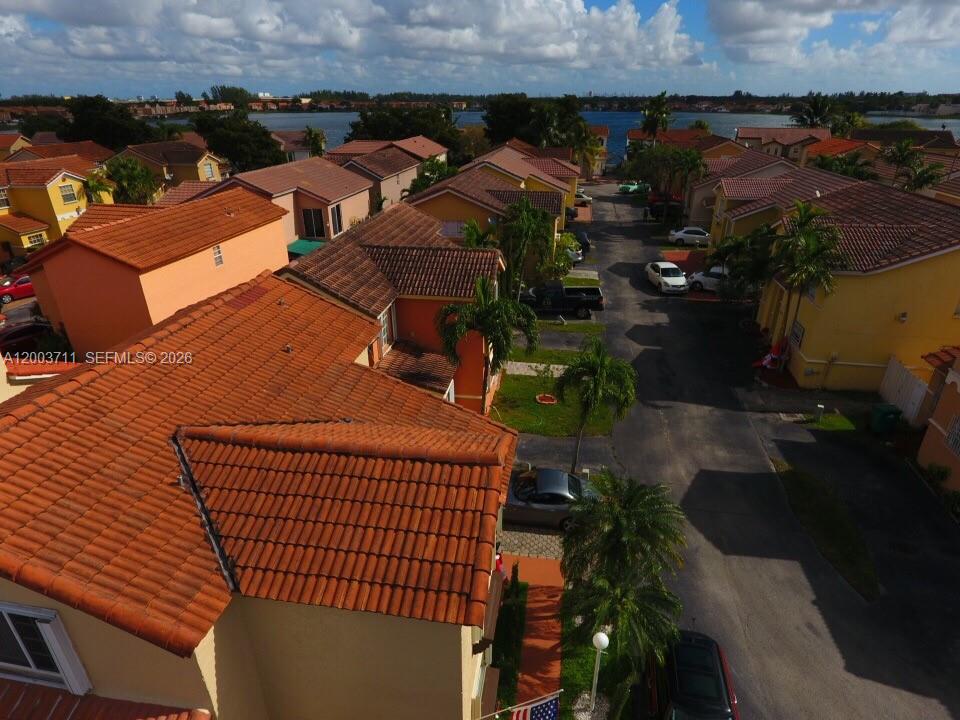 An aerial view shows a residential neighborhood with terracotta-tiled roofs and a paved street — 12693 NW 9th Ter, Miami FL 33182, MIAMI, FL