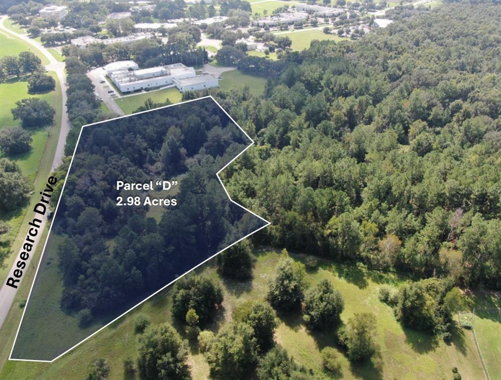 An aerial view shows a 2.98-acre wooded parcel of land bordering a road — RESEARCH DRIVE, ALACHUA, FL