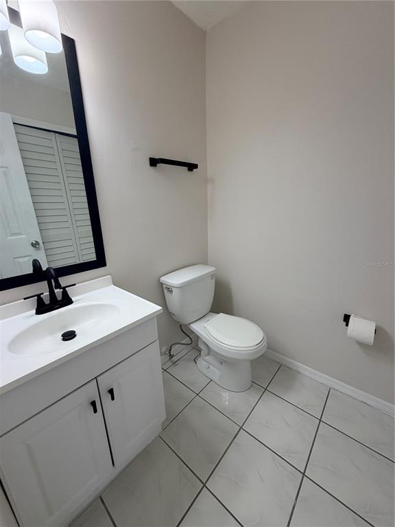A bathroom features a white vanity with a black faucet, a toilet, and tiled flooring — 1625 LONG RIDGE COURT UNIT 271, ORLANDO, FL