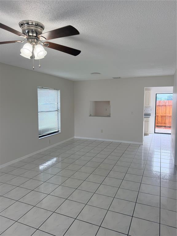 A room with white tiled floors, a ceiling fan, a window, and a wall cutout — 1625 LONG RIDGE COURT UNIT 271, ORLANDO, FL
