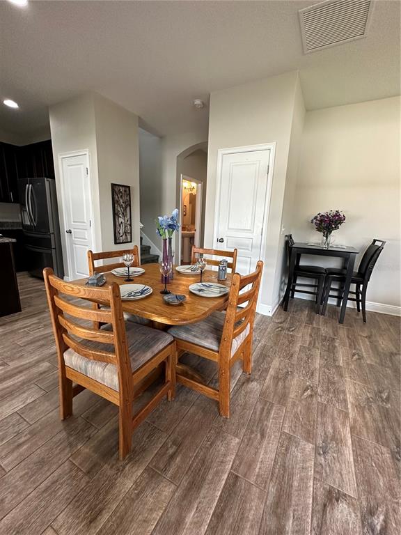 A dining area features a wooden table with four chairs and wood-look tile flooring — 3313 W WALNUT STREET, TAMPA, FL