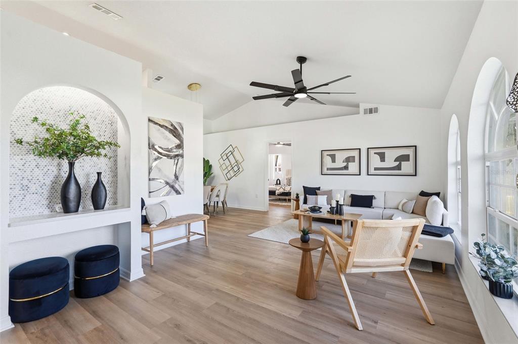 A bright living room features light wood flooring, a vaulted ceiling, and an arched alcove — 4850 S SALFORD BOULEVARD, NORTH PORT, FL