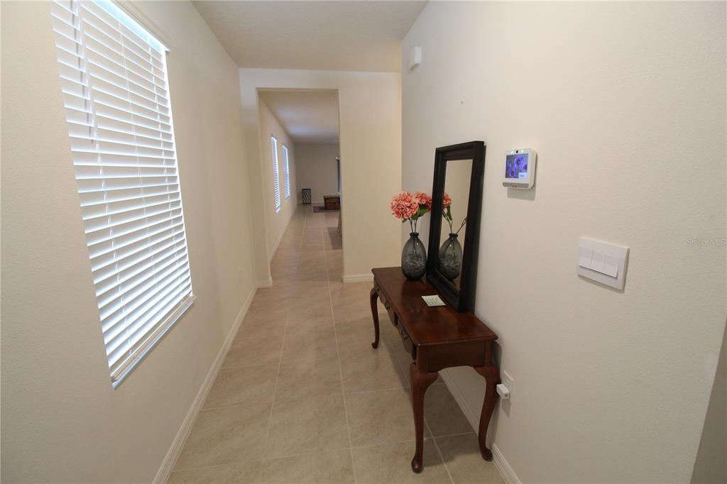A bedroom features a black metal bed frame, a red throw blanket, and two floor lamps — 423 PELHAM PARK DRIVE, DELAND, FL