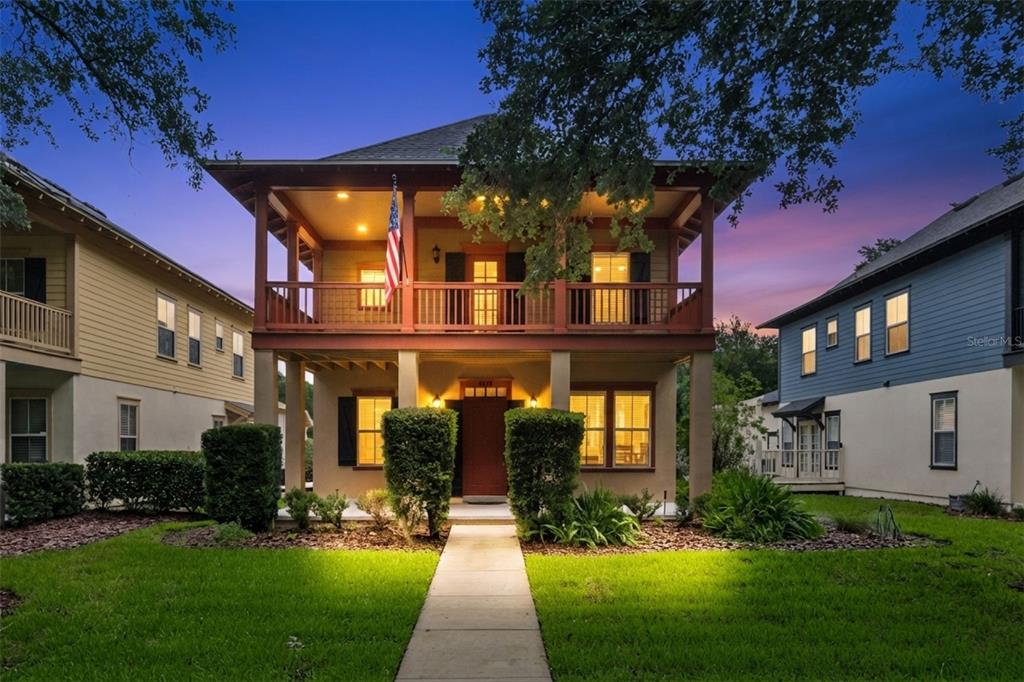 A two-story house with a front porch, balcony, and a walkway leading to the entrance — 1017 OLD BLUSH ROAD, KISSIMMEE, FL