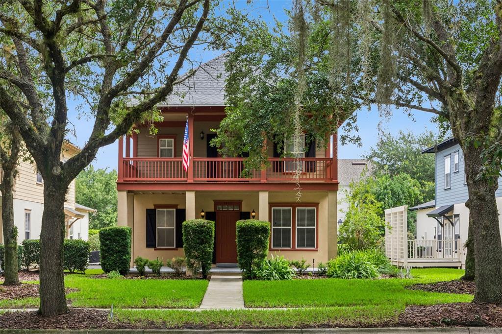 A two-story house with a front porch, balcony, and a walkway through the front yard — 1017 OLD BLUSH ROAD, KISSIMMEE, FL