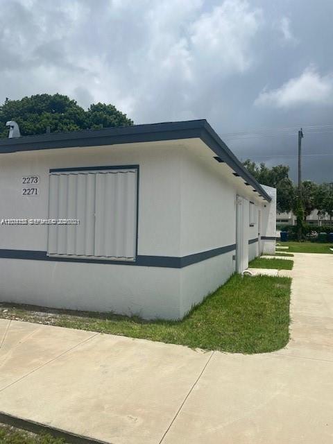 A white one-story building with a flat roof and accordion hurricane shutters on the window — 2271/2273 NW 66th St, Miami FL 33147, MIAMI, FL