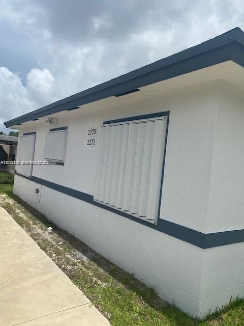 The exterior of a white building features dark trim and windows covered by metal shutters — 2271/2273 NW 66th St, Miami FL 33147, MIAMI, FL