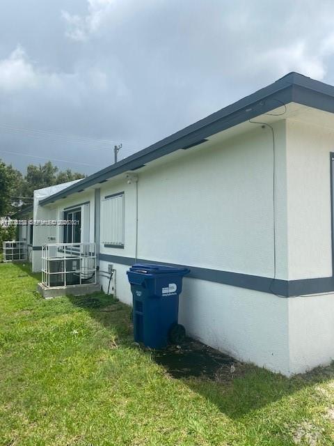 The exterior of a white house features a blue trash bin and an air conditioning unit — 2271/2273 NW 66th St, Miami FL 33147, MIAMI, FL