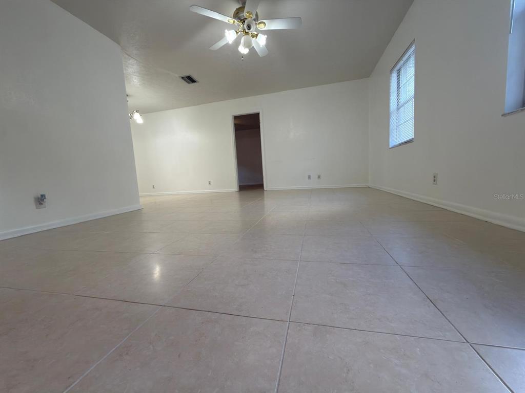 An empty room features light-colored tile flooring, white walls, and a ceiling fan — 2209 BOXWOOD WAY, BRANDON, FL