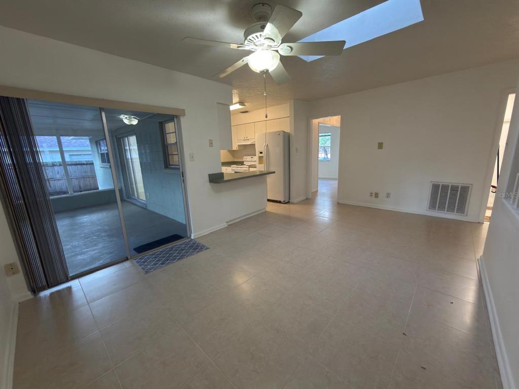 A tiled dining area features a ceiling fan, sliding glass doors, and an open kitchen — 2209 BOXWOOD WAY, BRANDON, FL