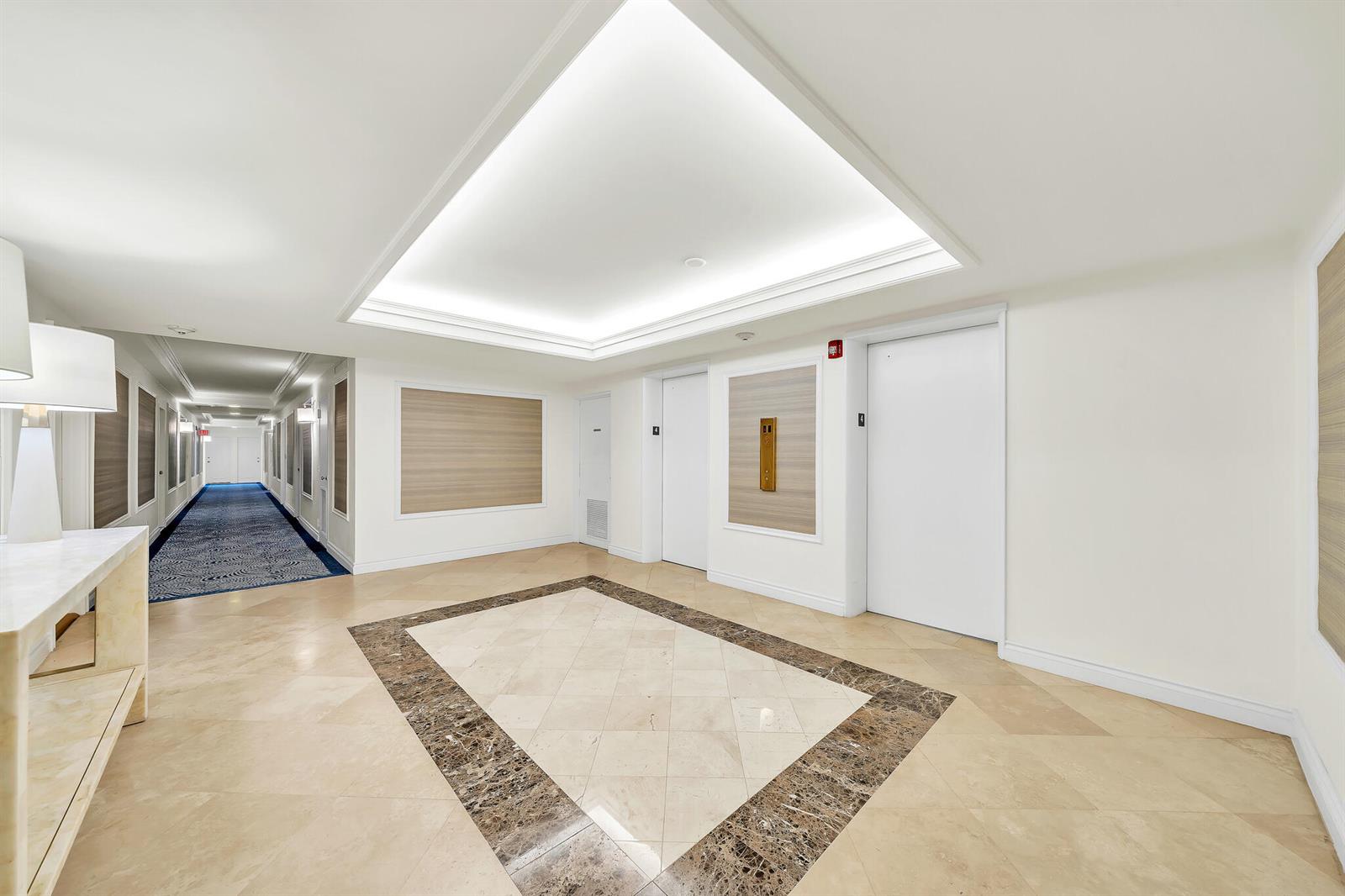 A hotel elevator lobby features marble floors, white walls, and a recessed ceiling light — 250 N Bradley Place # 402, Palm Beach FL 33480, PALM BEACH, FL