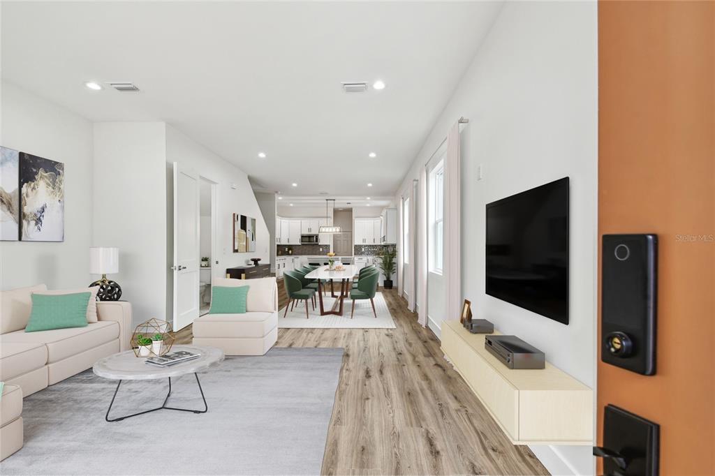 An open-concept living and dining area features light wood flooring, white walls, and modern furniture — 3455 17TH AVENUE S, ST PETERSBURG, FL