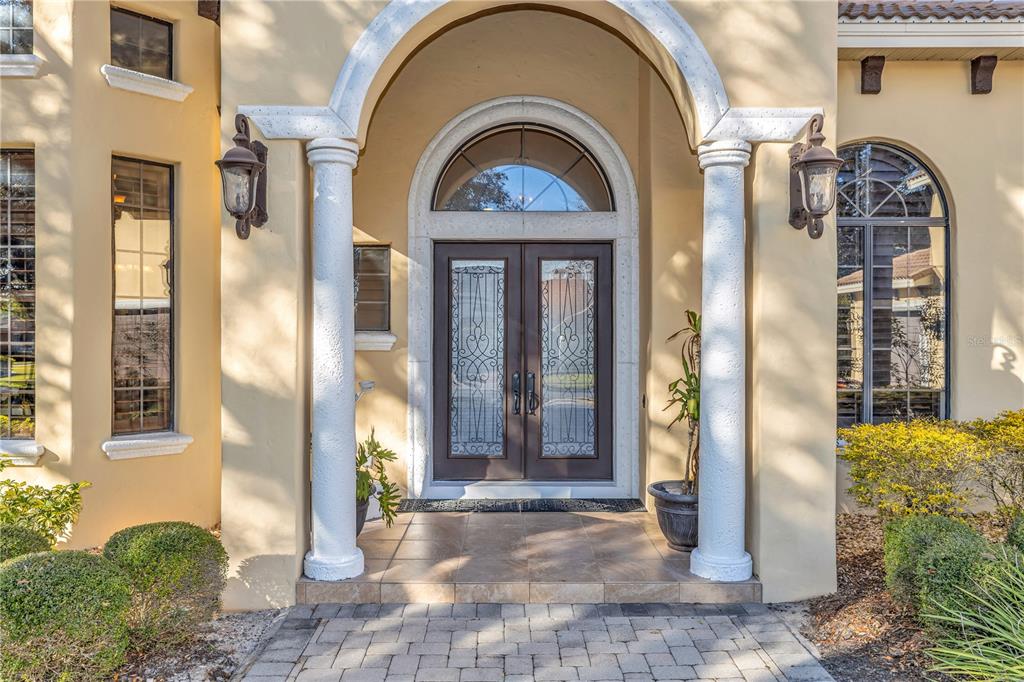 A front entryway features double glass doors under an arched portico with two white columns — 25514 HIGH HAMPTON CIRCLE, SORRENTO, FL