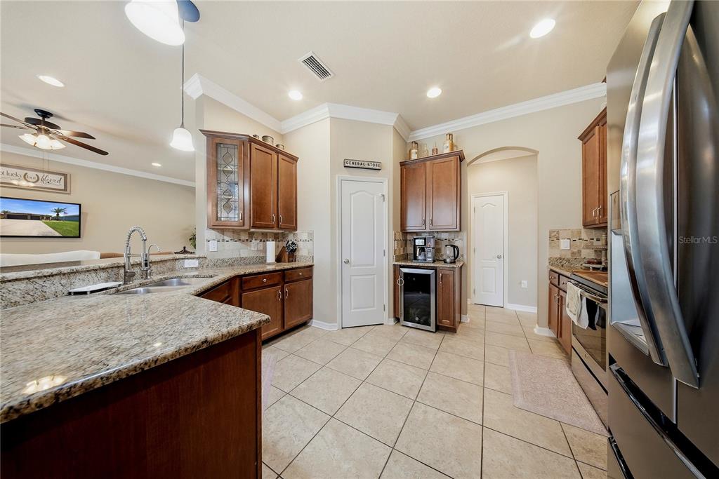 A kitchen with granite countertops, wooden cabinets, stainless steel appliances, and tile flooring — 354 HOPE BAY LOOP, APOLLO BEACH, FL