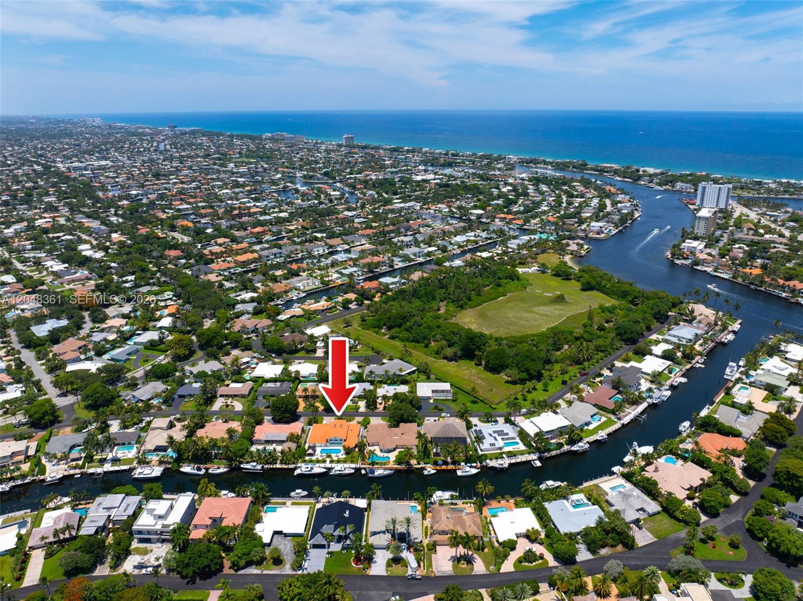 This aerial view shows a waterfront residential neighborhood with a red arrow pointing to a house — 2770 NE 23rd Pl, Pompano Beach FL 33062, POMPANO BEACH, FL