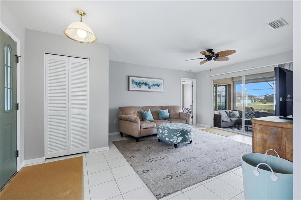 A living room features light gray walls, white tile floors, a beige sofa, and sliding doors — 175 BUNKER ROAD, ROTONDA WEST, FL