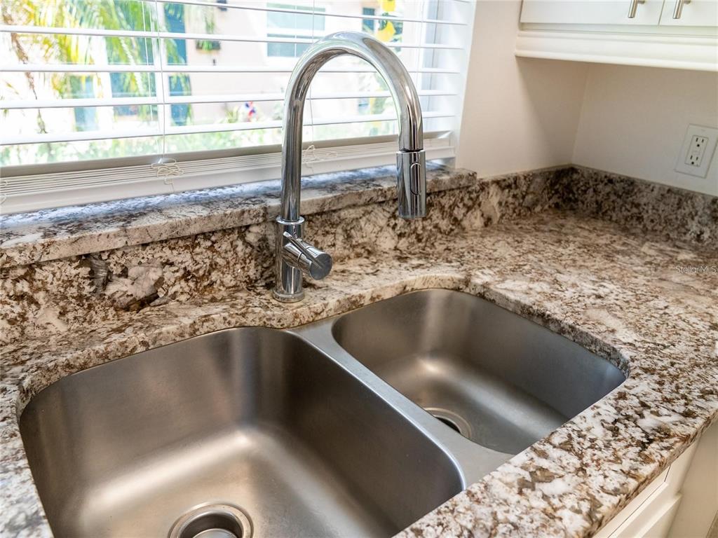 A stainless steel double-basin sink with a chrome faucet set in granite countertops — 517 S SUMMERLIN AVENUE, ORLANDO, FL