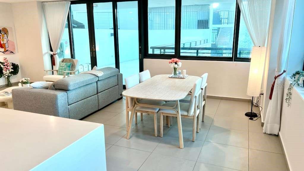 A bright living and dining area features light-colored tile floors and large sliding glass doors — 1511 PONCE DE LEON AVENUE UNIT 923, SANTURCE, PR