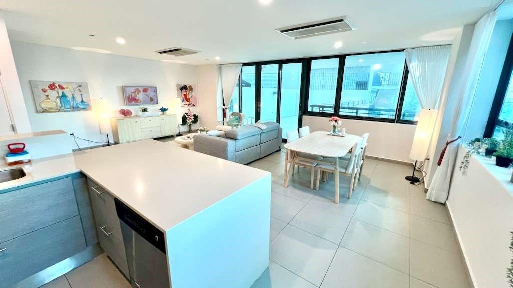 A modern open-concept living and dining area features a kitchen island and floor-to-ceiling windows — 1511 PONCE DE LEON AVENUE UNIT 923, SANTURCE, PR