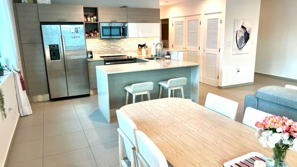 A modern kitchen features stainless steel appliances, light wood cabinetry, and a white island — 1511 PONCE DE LEON AVENUE UNIT 923, SANTURCE, PR