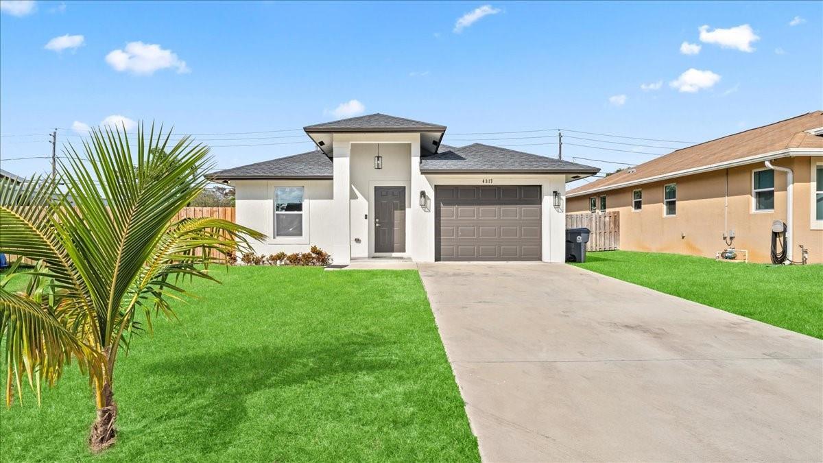 A single-story house with a white exterior, a dark roof, and a concrete driveway — 4317 Vicliff Road, West Palm Beach FL 33406, WEST PALM BEACH, FL