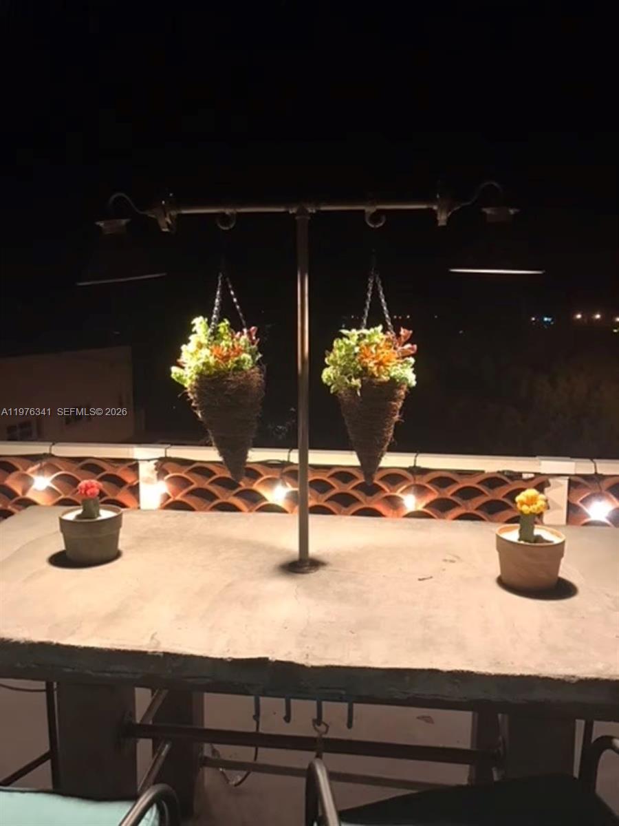 A concrete outdoor table features two hanging planters and small potted cacti at night — 12400 Overseas Hwy, Marathon FL 33050, MARATHON, FL