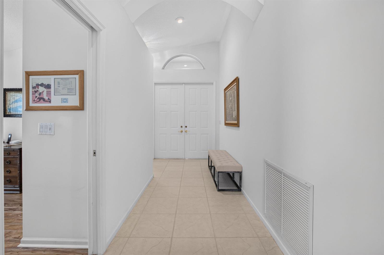 A tiled entryway features a vaulted ceiling, double front doors, and a cushioned bench — 5293 Grey Birch Lane, Boynton Beach FL 33437, BOYNTON BEACH, FL