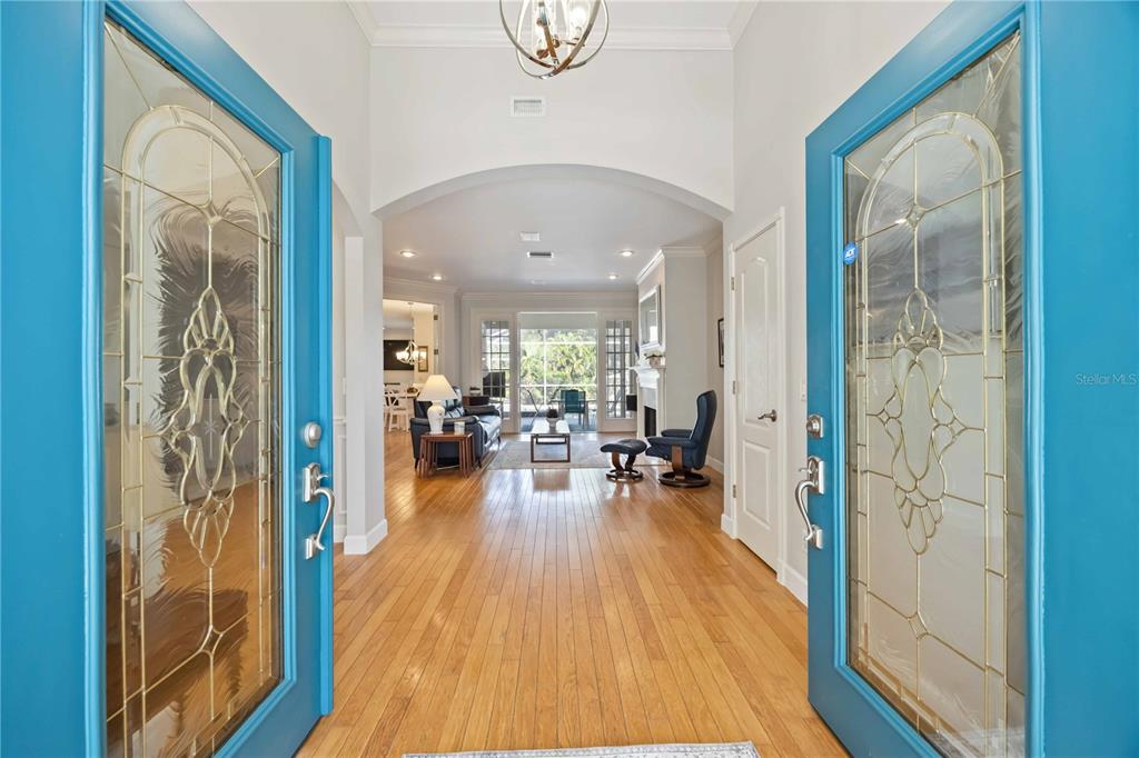 A view through a bright blue double front door into a home's hardwood-floored entryway — 1860 CITRON STREET, PORT CHARLOTTE, FL