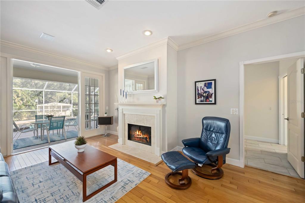 A living room features a fireplace, a blue leather recliner, and glass doors to a patio — 1860 CITRON STREET, PORT CHARLOTTE, FL