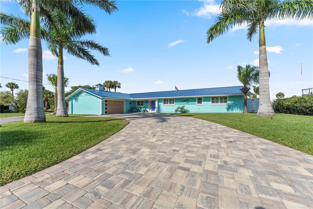 A light blue single-story house with a metal roof and a paved driveway — 118 CORAL WAY, PORT ORANGE, FL