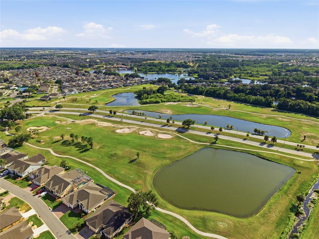 An aerial view shows a residential neighborhood bordering a golf course with multiple ponds — 237 GOLF VISTA DRIVE, DAVENPORT, FL