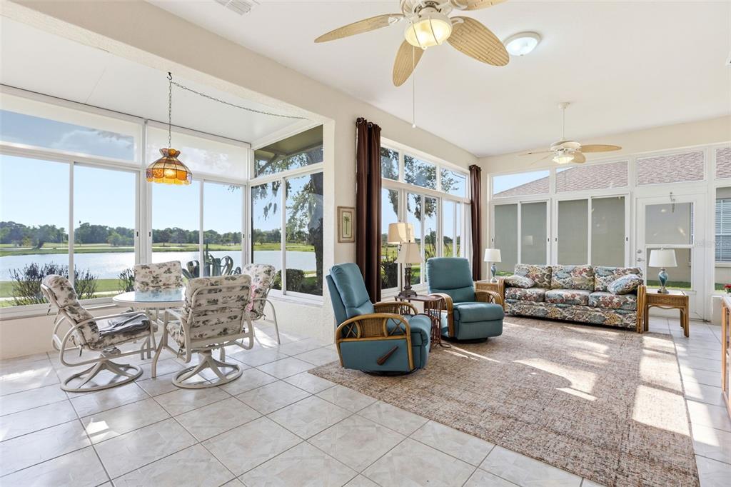 A sunroom with tile floors, two ceiling fans, and a view of a lake outside — 237 GOLF VISTA DRIVE, DAVENPORT, FL