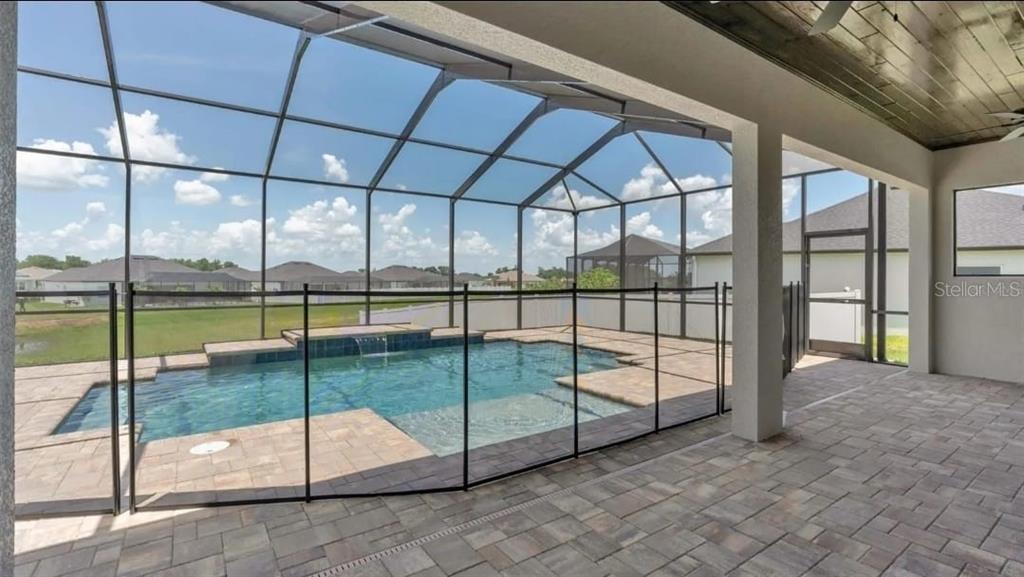 A bedroom with light wood floors, a tray ceiling, a ceiling fan, and French doors — 6980 BENTRIDGE DRIVE, LAKELAND, FL