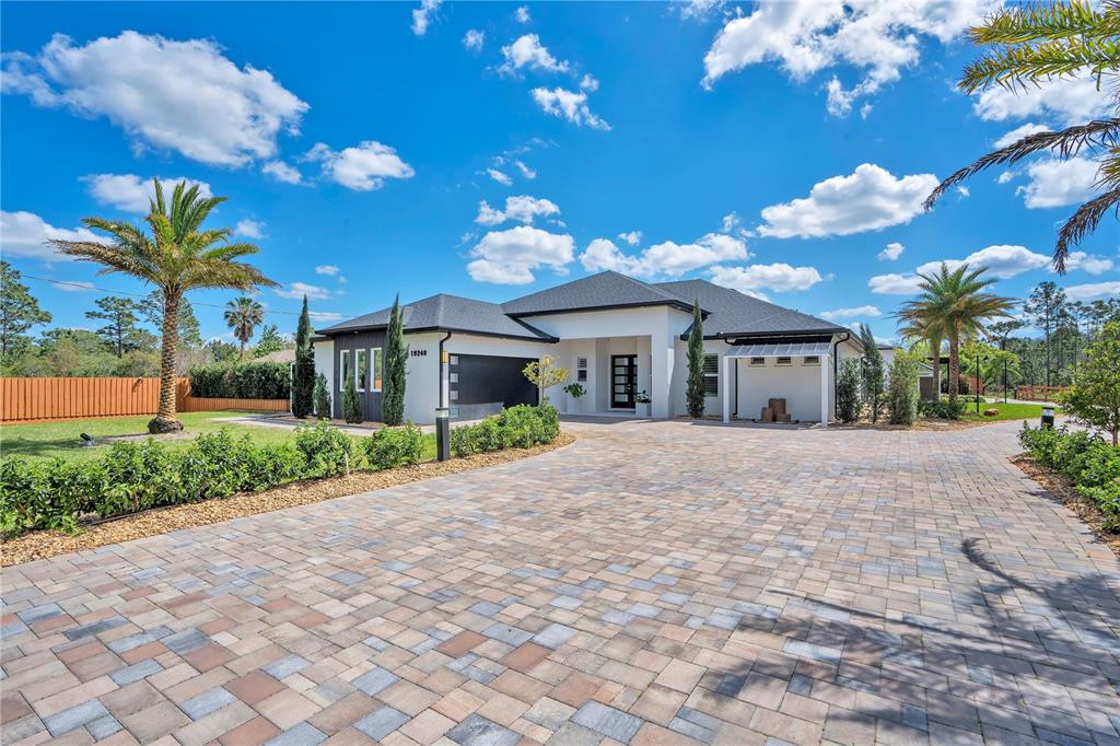 A modern white house with a dark roof and a large paved driveway — 19240 LANSDOWNE STREET, ORLANDO, FL
