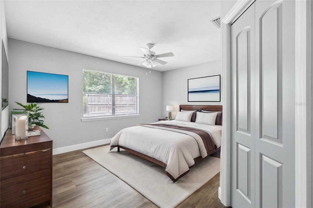 A bedroom with light gray walls, wood-look flooring, a ceiling fan, and a queen bed — 6226 NW 53RD TERRACE, GAINESVILLE, FL