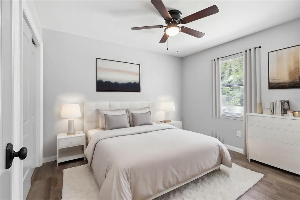 A bedroom features a white bed, two nightstands, a dresser, and a ceiling fan — 6226 NW 53RD TERRACE, GAINESVILLE, FL