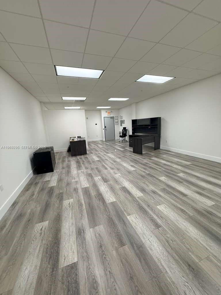 An office space features white walls, a drop ceiling with recessed lighting, and wood-look flooring — 7791 NW 46th St # 201, Doral FL 33166, DORAL, FL