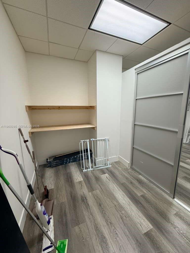 A small room features wood-look flooring, two wall-mounted shelves, and a sliding closet door — 7791 NW 46th St # 201, Doral FL 33166, DORAL, FL