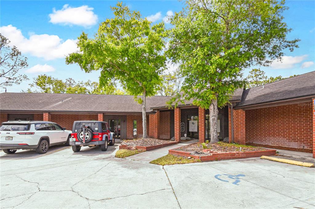 A single-story brick commercial building with a parking lot and two large trees in front — 1840 DUNN AVENUE UNIT 6, JACKSONVILLE, FL