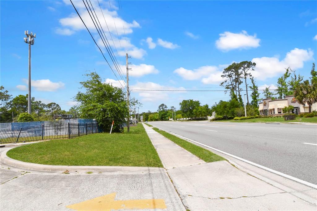 A view of a paved road, sidewalk, and grassy area with a chain-link fence — 1840 DUNN AVENUE UNIT 6, JACKSONVILLE, FL