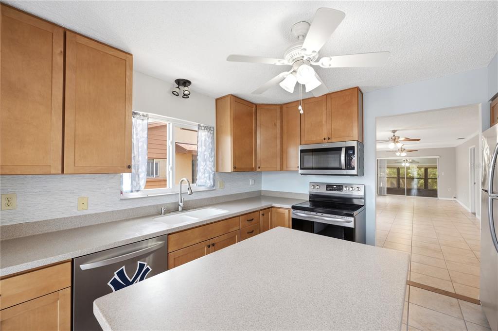 A kitchen with light wood cabinets, stainless steel appliances, and a central island — 3820 LIGHTHOUSE WAY, NEW PORT RICHEY, FL