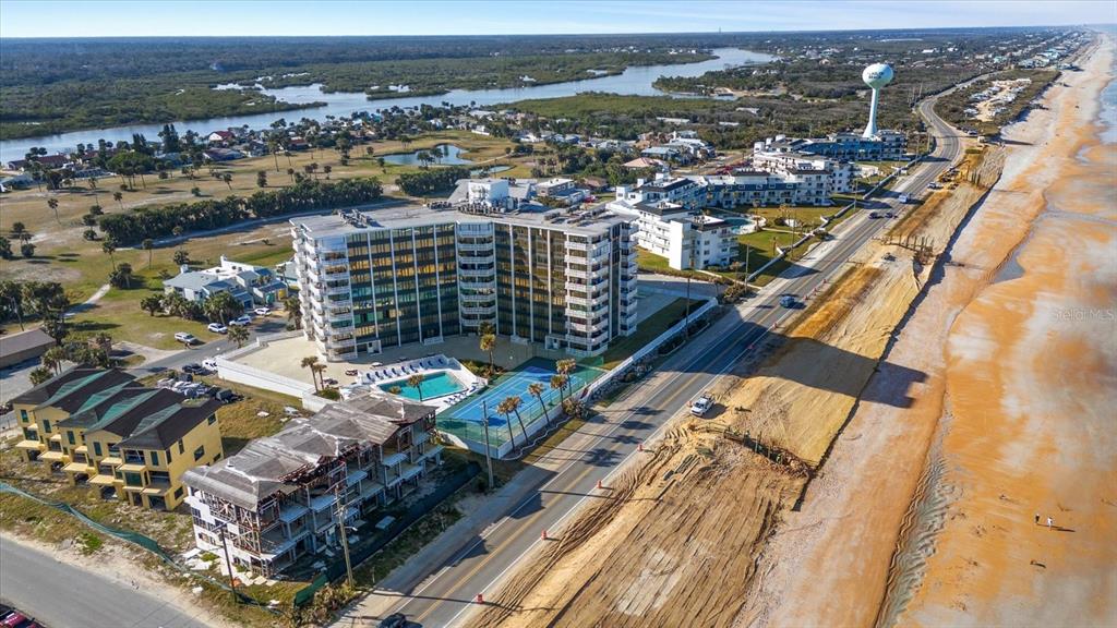 An aerial view shows a beachfront condominium complex with a pool and tennis court — 3580 S OCEAN SHORE BOULEVARD UNIT 204, FLAGLER BEACH, FL
