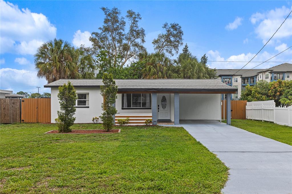 A single-story house with a white exterior, a front carport, and a concrete driveway — 9581 49TH WAY N, PINELLAS PARK, FL
