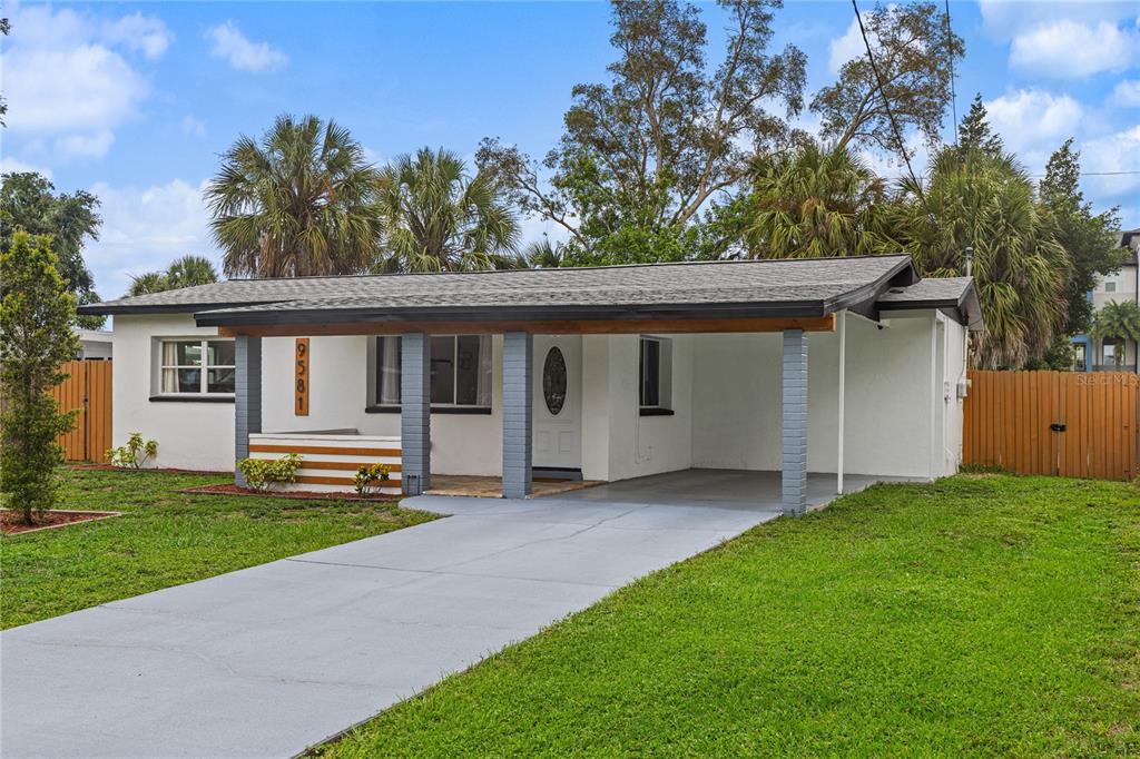 A single-story house with a white exterior, a carport, and a front porch — 9581 49TH WAY N, PINELLAS PARK, FL