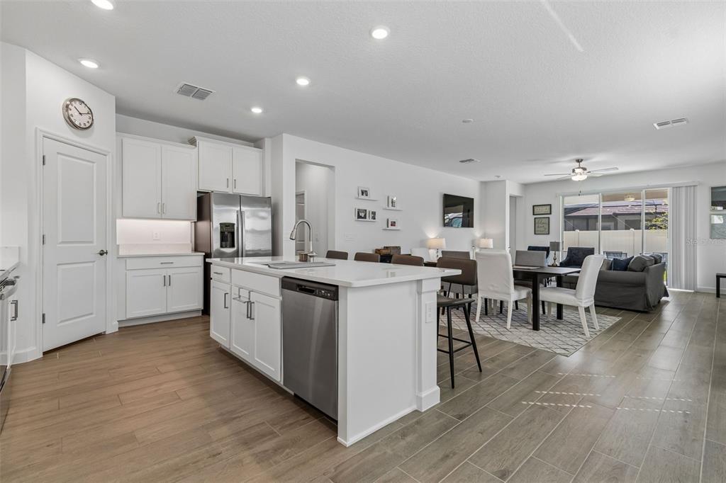 A modern kitchen with white cabinetry, a central island, and wood-look tile flooring — 31735 GRIFFIN SANDS LANE, SAN ANTONIO, FL