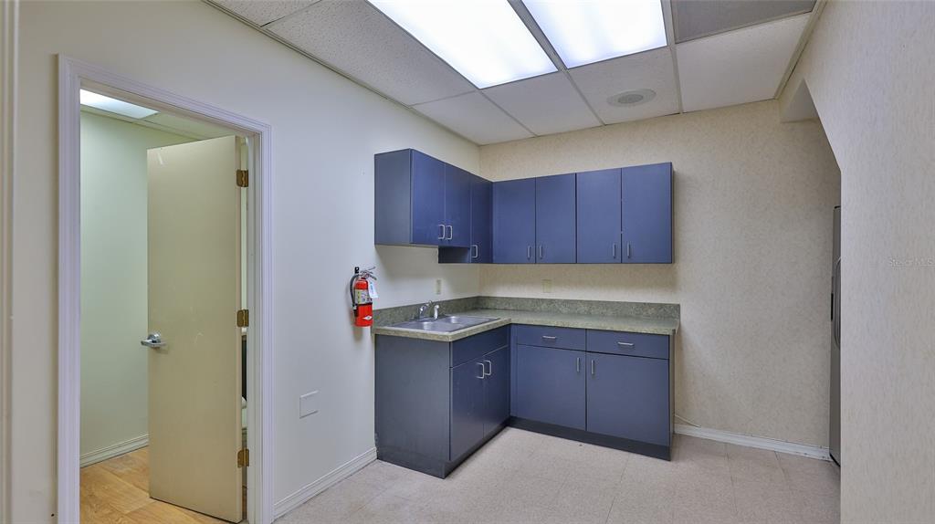 A small break room features blue cabinets, a stainless steel sink, and a fire extinguisher — 4 OLD KINGS ROAD N UNIT 2A, PALM COAST, FL