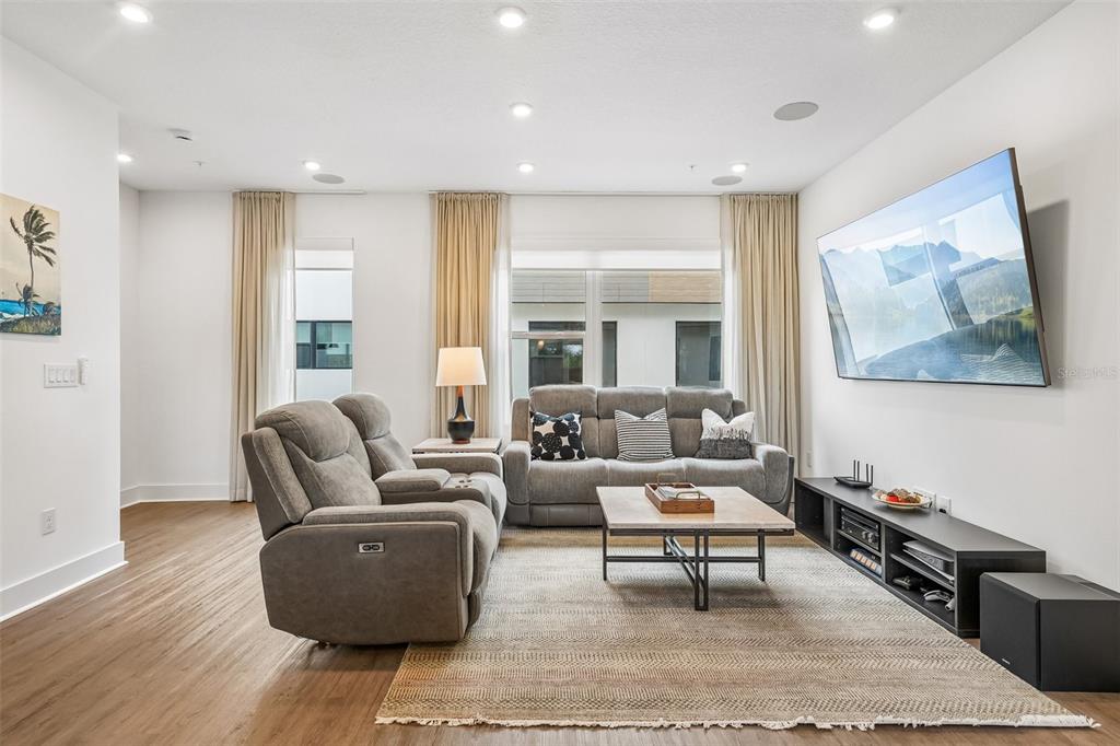 A living room features gray reclining furniture, a wooden coffee table, and a wall-mounted television — 312 15TH STREET N, ST PETERSBURG, FL