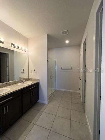 A bathroom features a double vanity with dark cabinets, granite countertops, and a glass shower — 228 HILLCREST DRIVE, DUNDEE, FL